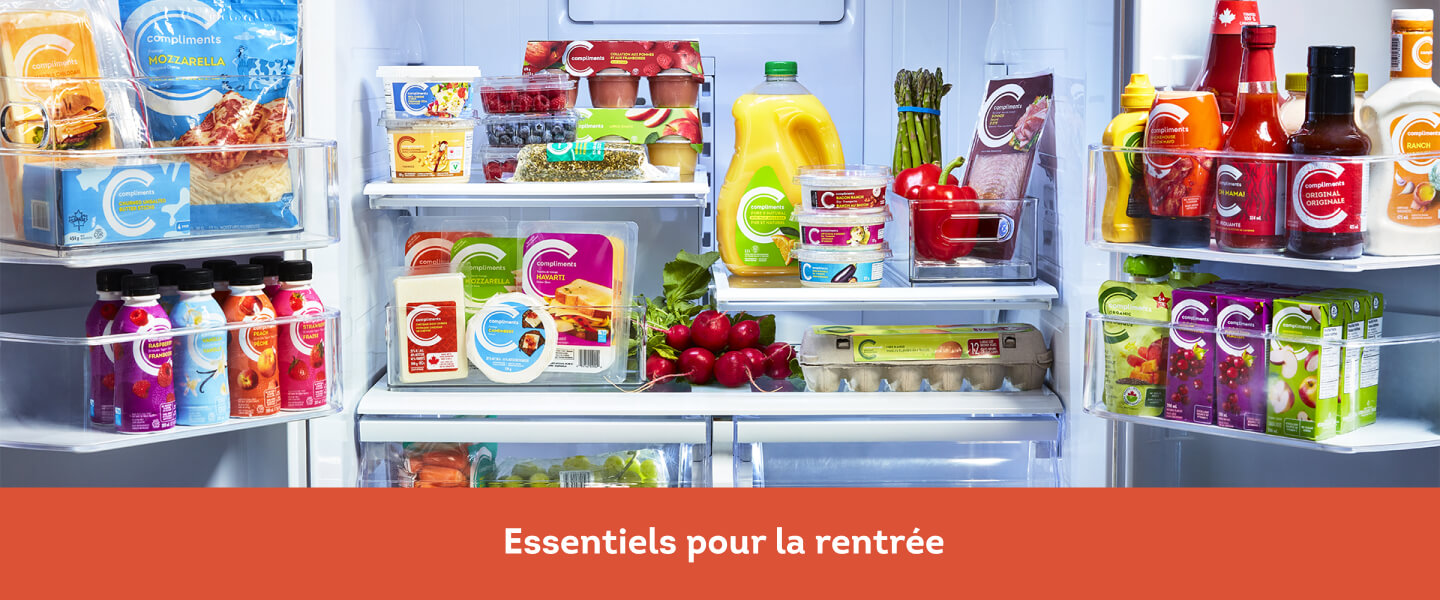 L’intérieur d’un réfrigérateur rempli de légumes, œufs, fromages, boissons et condiments